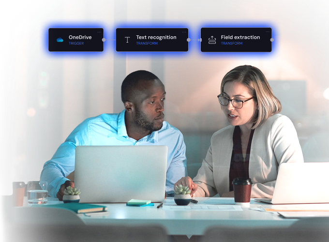 Two colleagues at laptops beneath a document workflow: OneDrive trigger, text recognition, then field extraction.